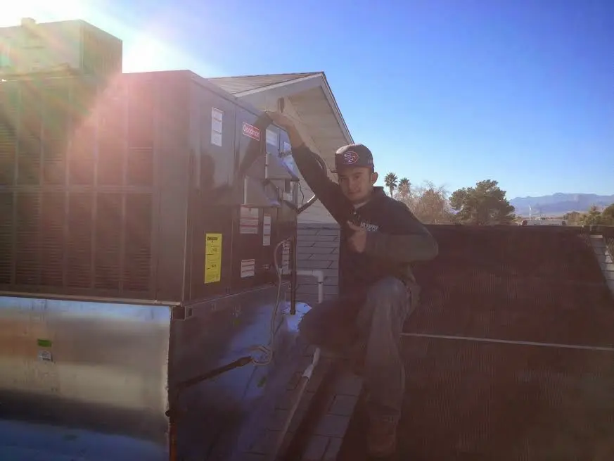 HVAC technician performing Heat Pump Repair on a rooftop unit in Stow